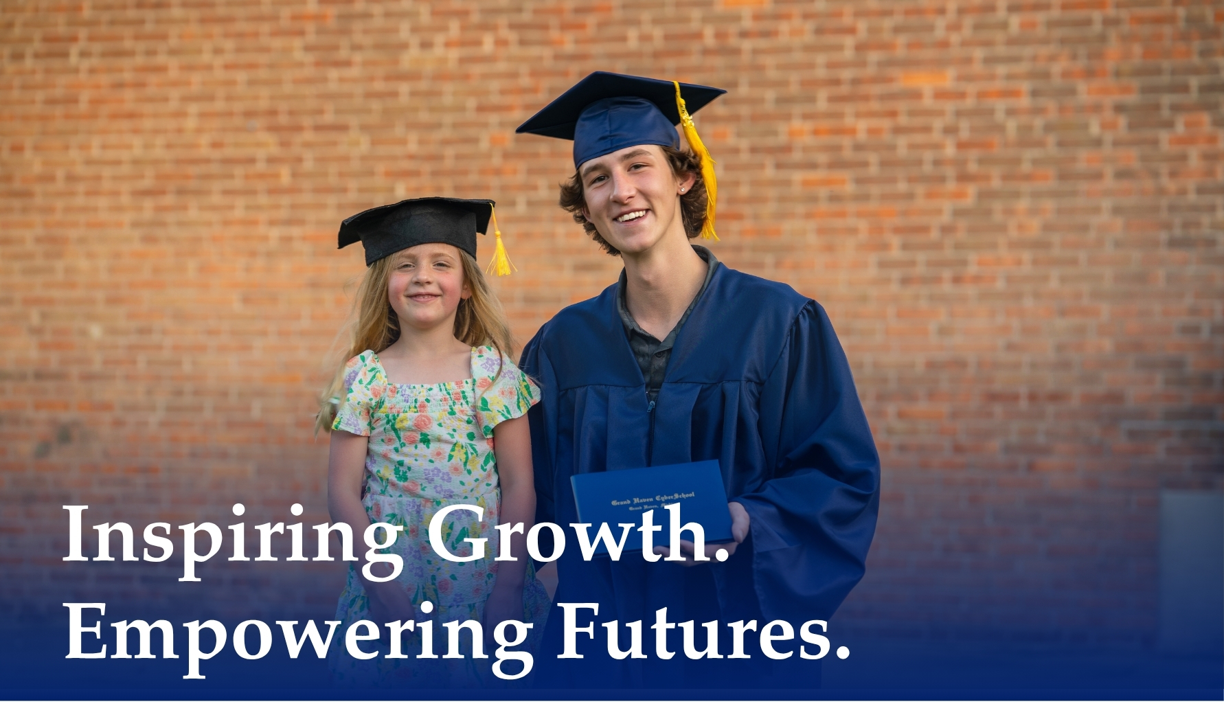 A high school graduate in his cap and gown standing with a younger sister who is also wearing a grad cap as both smile.