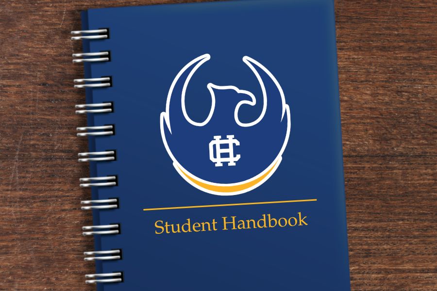 A photo of a notebook on a wooden table with the Central High School Phoenix logo, a ruled line, and the words Student Handbook.