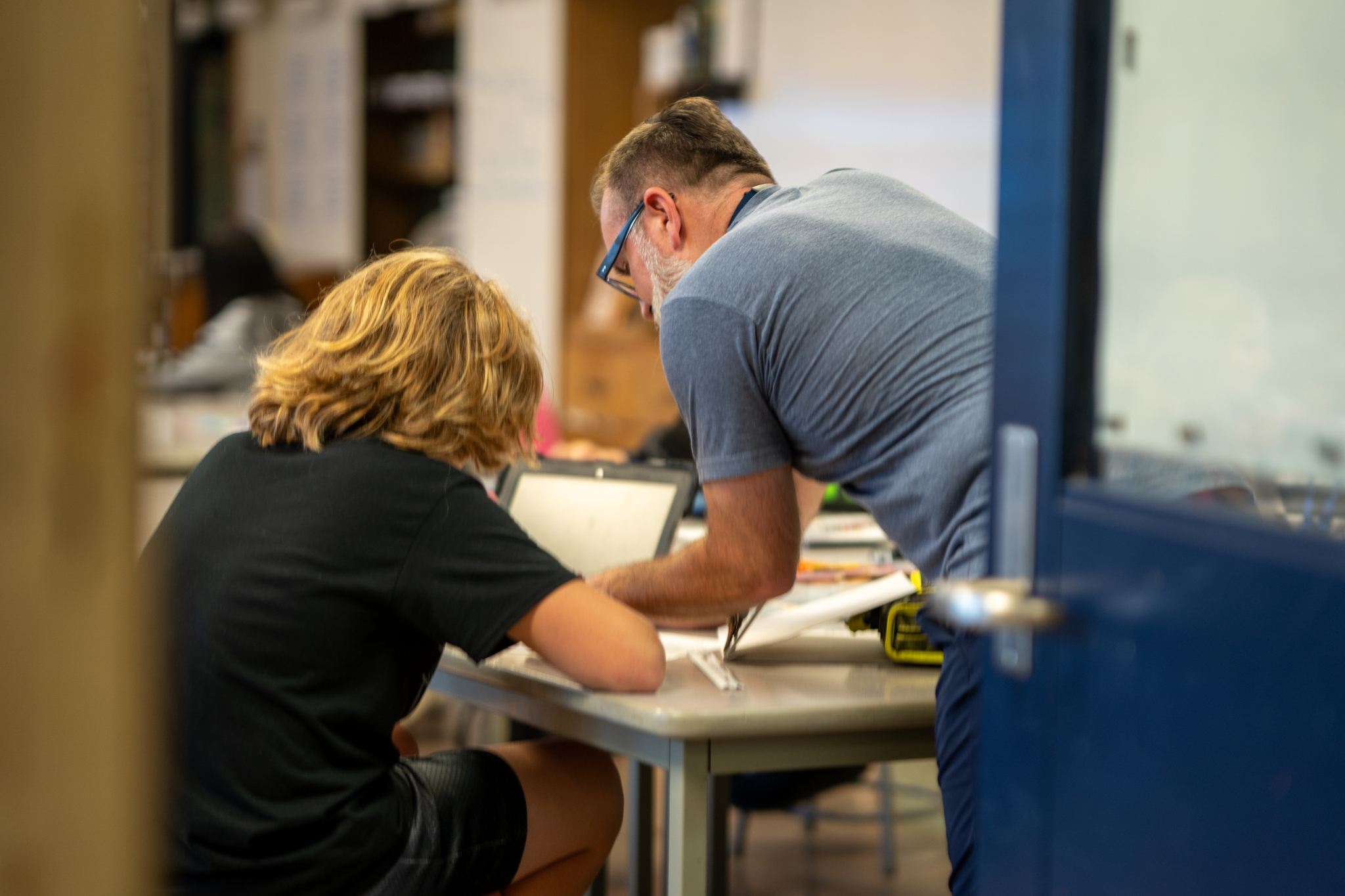 A teacher helping a student with homework