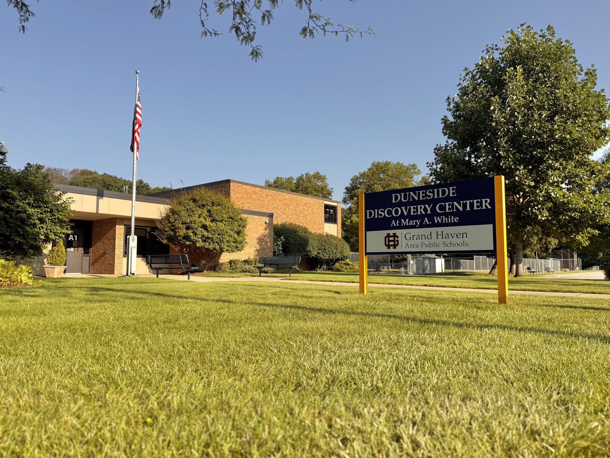 A photo of Duneside Discovery Center and its building sign in front of the building.