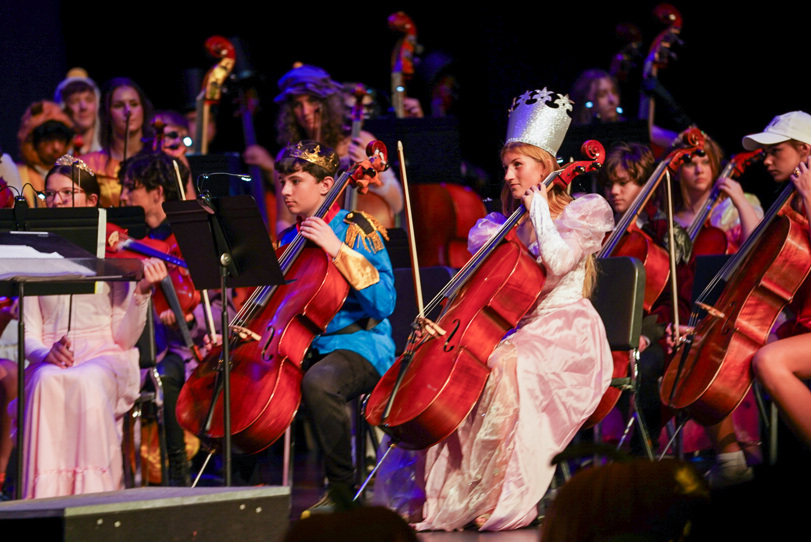 A student dressed in a princess costume while performing in an orchestra performance