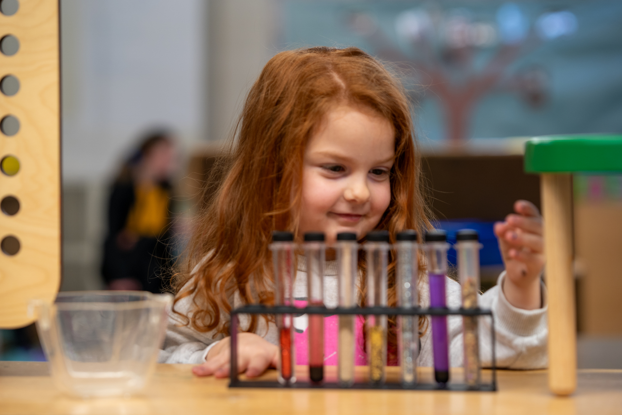A young preschool student playing with colorful viles.
