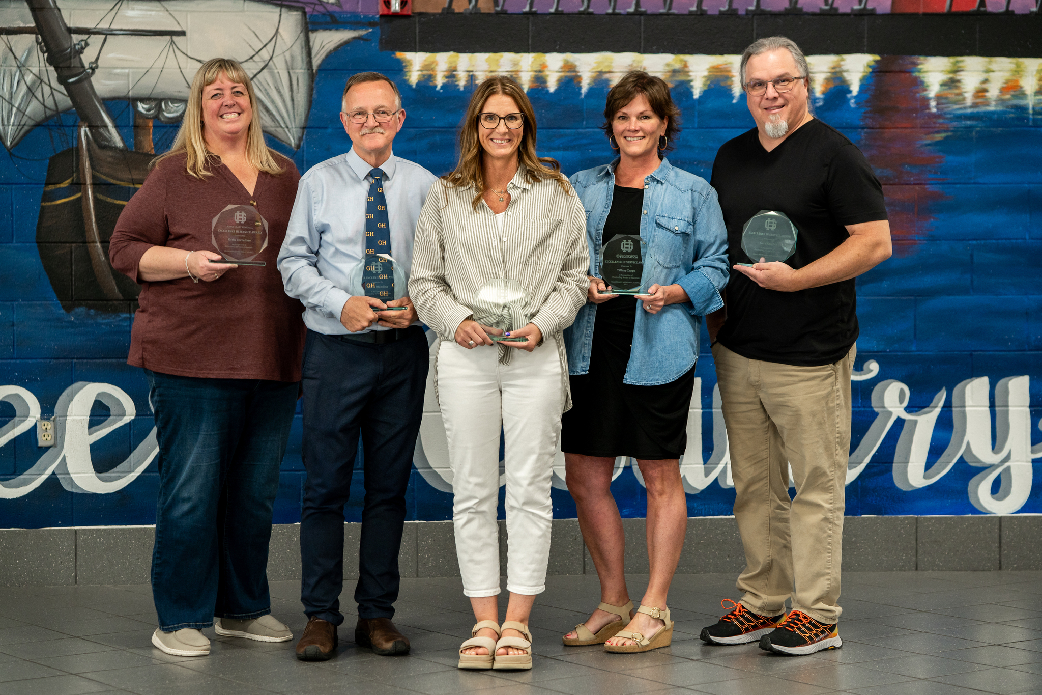 The five 2025 Excellence in Service Award Winners pictured with their awards